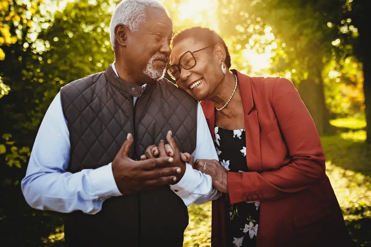 Older couple sharing a warm moment outdoors, representing supportive care for Alzheimer's disease