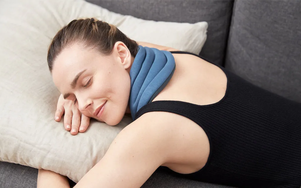 Woman resting with a neck pillow to ease neck pain and tension