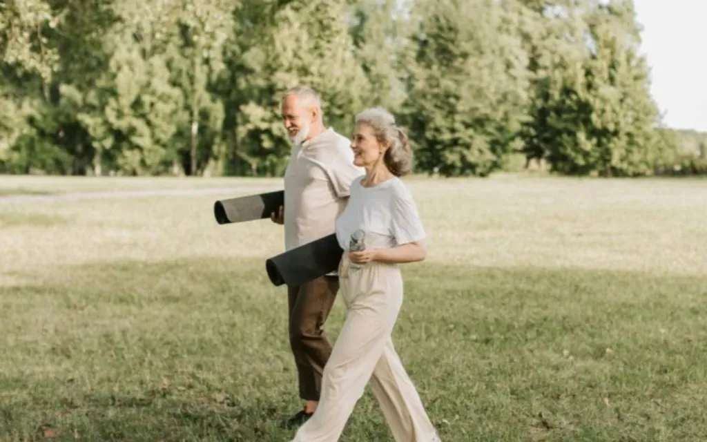 Older couple walking together outdoors, enjoying an active life